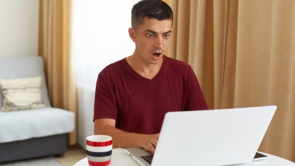 indoor_shot_astonished_male_freelancer_working_online_looking_notebook_display_with_widely_opened_mouth_having_system_error_being_scared_loose_done_work-_1_